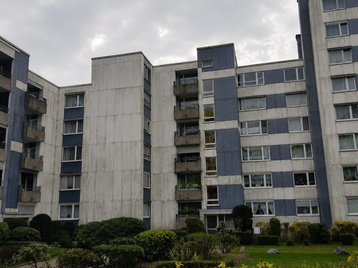 Vorher: Wohnanlage mit Eternit-Faserzementfassade in Monheim am Rhein vor und nach der Reinigung von 3.100 m²